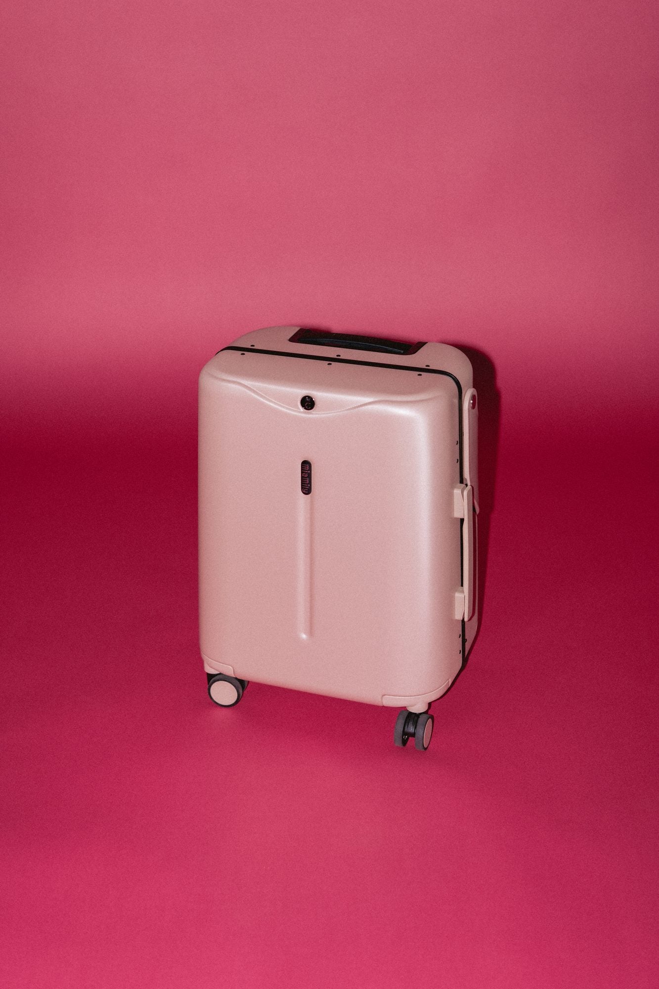 Dusty Pink Carry On on a red studio backdrop