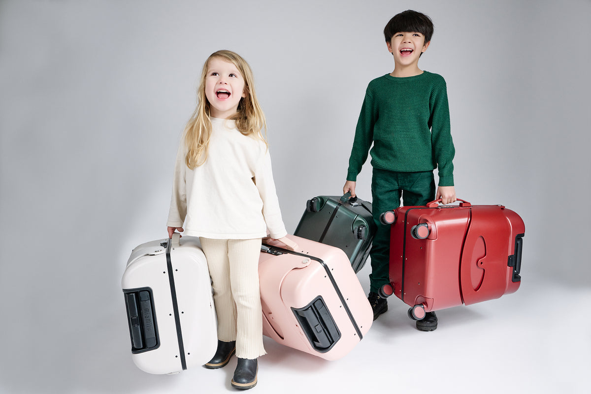 Two children playing on Burgundy Red and Navy Blue Carry On cases