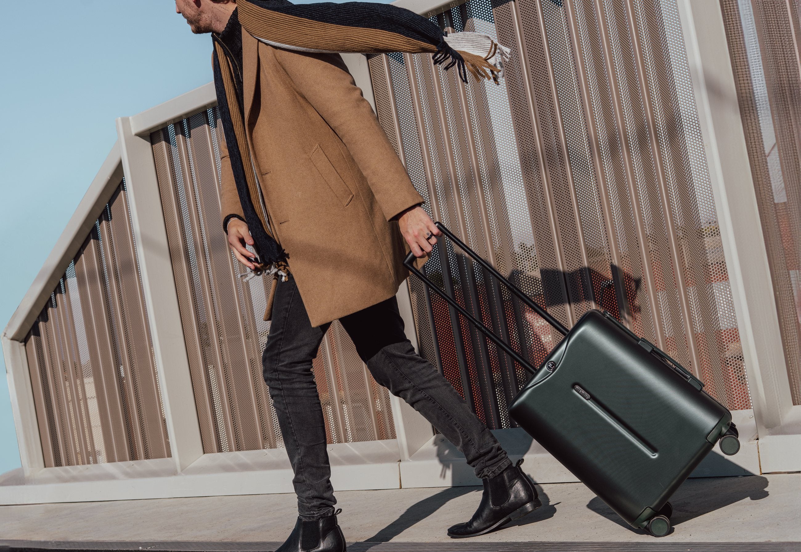 Pulling a Forest Green Carry On across a bridge